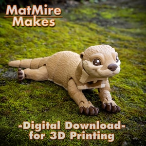 May include: A 3D printed model of a brown and tan otter with large eyes and a friendly expression. The otter is posed on its belly with its front paws extended. The text "MatMire Makes - Digital Download - for 3D Printing" is displayed below the otter.