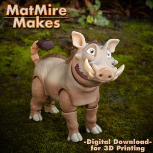 Könnte beinhalten: Ein 3D-gedrucktes Modell eines Warzenschweins mit beweglichen Gliedmaßen. Das Warzenschwein ist braun und hat eine strukturierte Oberfläche. Das Modell steht auf einem Bett aus grünem Moos. Der Text "MatMire Makes" ist im Hintergrund sichtbar.