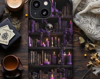 May include: Black phone case featuring a gothic bookshelf design with a skull, candles, and purple flowers. The case has a dark, mysterious aesthetic, with a detailed illustration of books and candles. The overall theme is a blend of fantasy and vintage elements.