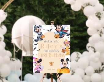 May include: Welcome to Riley's not so scary First Birthday sign with a white background and Mickey Mouse characters dressed in Halloween costumes. The sign has a light brown circle with the text "Welcome to Riley's not so scary First Birthday" and the date "09.12.2023".