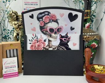 May include: A black and white illustration of a skeleton wearing pink sunglasses and a pink flower crown. The skeleton is holding a black cat wearing pink sunglasses. The background is a light purple with pink hearts.