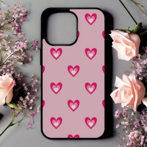 May include: A pink phone case with a repeating pattern of white and pink hearts.