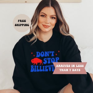 May include: Black sweatshirt with a blue and red graphic that says "Don't Stop Believin'" with a red buffalo silhouette.