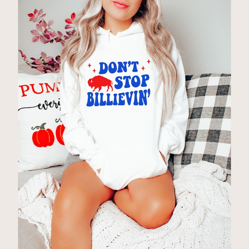 May include: White hoodie with a blue and red graphic that says "Don't Stop Billievin'" with a red buffalo silhouette.