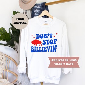 May include: White sweatshirt with a red buffalo and blue text that reads "Don't Stop Billievin'" with stars above the text.