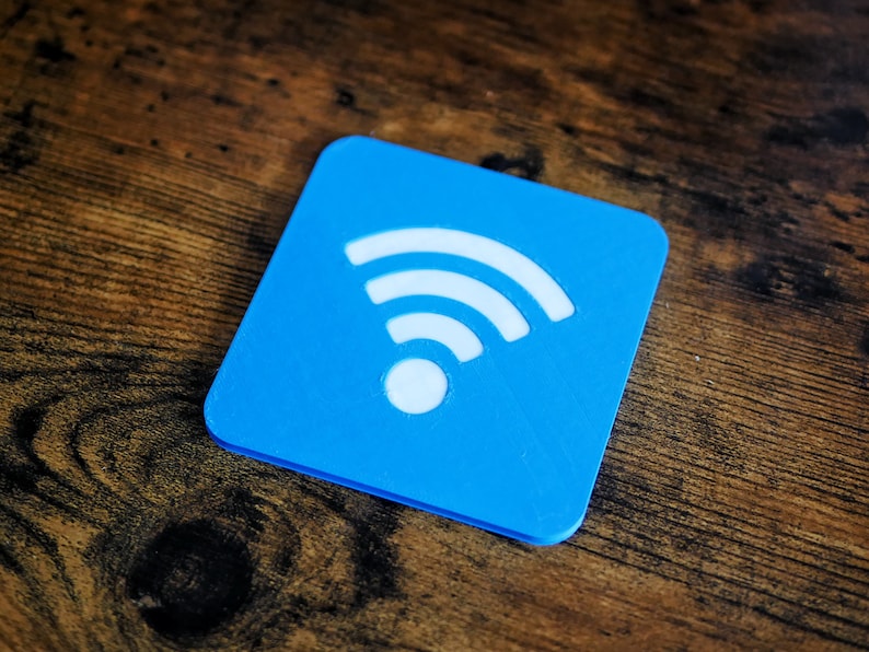 Op de afbeelding: Een blauwe vierkante onderzetter met een wit wifi-symbool.