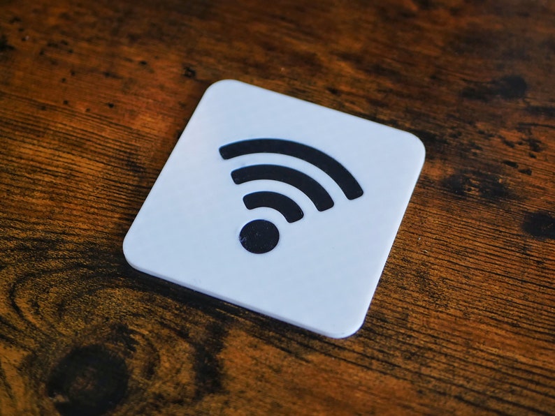Op de afbeelding: Een witte vierkante onderzetter met een zwart wifi-symbool.
