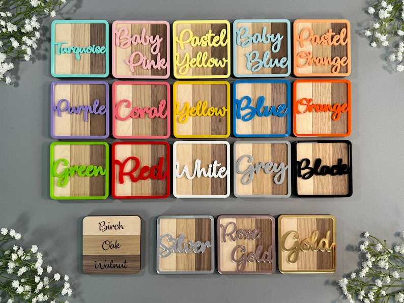 May include: A collection of colorful wooden coasters with various color names in cursive script. Each coaster features a wooden design with a colored border and a matching color name. Colors include turquoise, baby pink, pastel yellow, baby blue, and pastel orange.