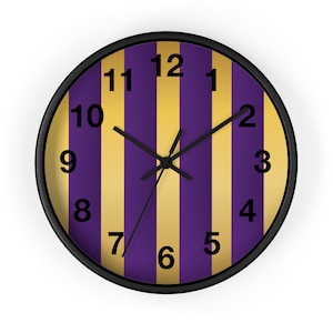 May include: A round wall clock with a black frame and a striped face. The stripes are alternating gold and purple. The clock face has black numbers 1 through 12.