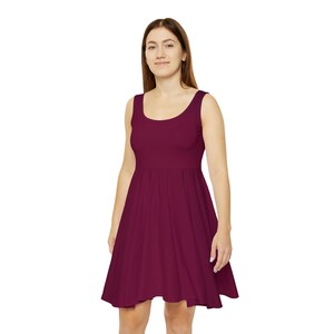 May include: A sleeveless, burgundy skater dress with a scoop neckline.