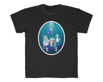 Könnte beinhalten: Schwarzes T-Shirt mit einer Grafik einer Person, die Basketball spielt, und drei Frauen mit blauen Haaren. Die Grafik befindet sich in einem weißen Oval. Der Hintergrund der Grafik ist blau mit vertikalen Linien.