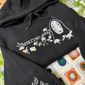 Moletom com Capuz Bordado "A Viagem de Chihiro - Sem Rosto", Estilo Anime Fantasia com Costura Floral, Unissex e Confortável com Estética Ghibli. imagem 2