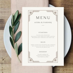 May include: A white menu card with a brown border and the text "MENU" in a decorative font. The names "AISHA & FAROOQ" are printed below the menu title. The menu lists starters, main courses, and desserts.