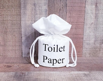 May include: White fabric toilet paper holder with the text "Toilet Paper" printed on the front.