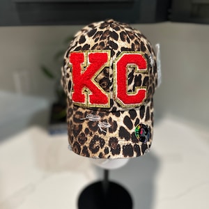 ponytail Leopard Hat with red and gold chenille letters and ponytail messy bun opening.