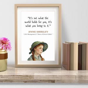 May include: A framed print with a quote by Anne Shirley from L.M. Montgomery's "Anne of Green Gables": "It's not what the world holds for you, it's what you bring to it." The print features an illustration of Anne Shirley with red hair and a green hat.