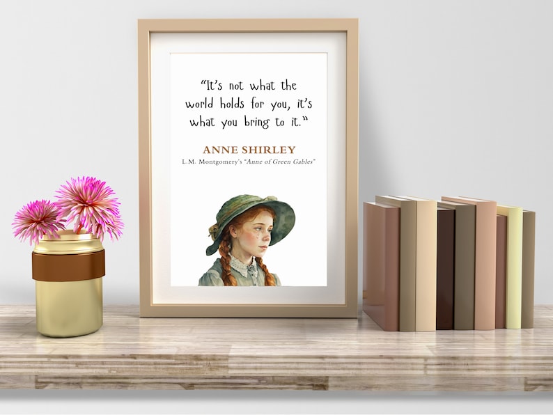 May include: A framed print with a quote by Anne Shirley from L.M. Montgomery's "Anne of Green Gables": "It's not what the world holds for you, it's what you bring to it." The print features an illustration of Anne Shirley with red hair and a green hat.