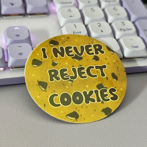 May include: A round yellow sticker with a brown cookie design. The sticker has the text "I NEVER REJECT COOKIES" in black.