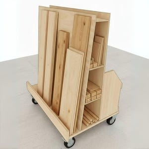 Op de afbeelding: Een houten kar op wielen, gevuld met verschillende maten onafgewerkte houten planken en planken. De kar heeft een ingebouwde plank aan de zijkant voor het opbergen van kleinere stukken hout en deuvels. De kar is ontworpen voor gemakkelijke mobiliteit en organisatie van hout.