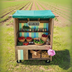 May include: A rustic wooden farm stand on wheels, displaying fresh produce. The stand has a green awning and a sign that reads "FARM FRESH." Baskets of tomatoes, apples, and green apples are visible, along with jars of preserves. The background shows a field.