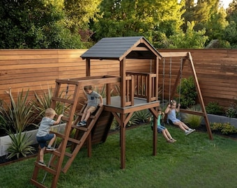 Puede incluir: Un parque infantil de madera con tobogán, escalera de escalada y columpios. El parque infantil tiene una pequeña estructura de casa con techo gris. Los niños juegan en el parque infantil en un jardín con césped y una valla de madera.