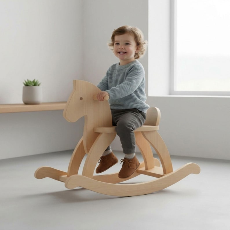 May include: A light-colored wooden rocking horse with a child sitting on it. The horse has a simple design with curved rockers and a seat. The child is wearing a blue sweater and gray pants.