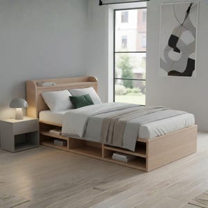 Puede incluir: Una cama de madera clara con cabecero y almacenamiento integrado. La cama está hecha con ropa de cama blanca, una almohada verde y una manta gris. Una mesita de noche gris con una lámpara está al lado de la cama.