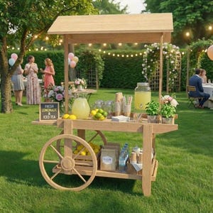 May include: A wooden lemonade cart with a canopy, stocked with lemons, limes, and iced tea. The cart features a sign saying "Fresh Lemonade & Iced Tea." The cart is positioned outdoors on a grassy lawn, with people in the background.