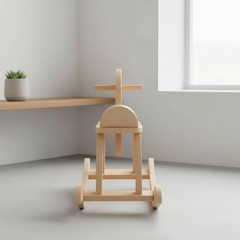 May include: A wooden rocking horse with a natural finish. The toy has a cross-shaped handle and a curved seat. The horse is designed with rounded edges and sits on two curved rockers. The toy is made of light-colored wood and is suitable for young children.