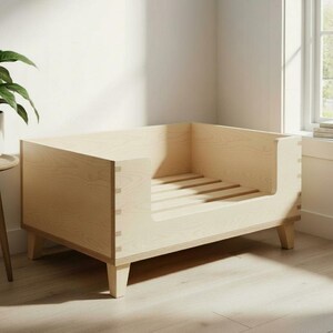 K&ouml;nnte beinhalten: Ein helles Hundebett aus Holz mit rechteckigem Rahmen und niedrigem Einstieg. Das Bett hat eine Lattenrost und steht auf vier kurzen Beinen. Die Holzmaserung ist sichtbar, und das Design ist minimalistisch.