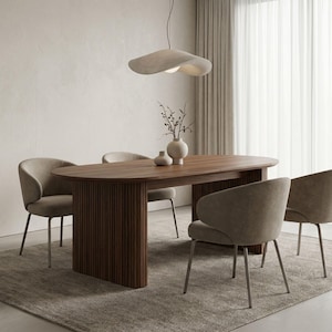 May include: A modern dining room set featuring a large, oval wooden table with a dark finish and four upholstered chairs. A unique, sculptural light fixture hangs above the table. The set is placed on a neutral-toned rug.