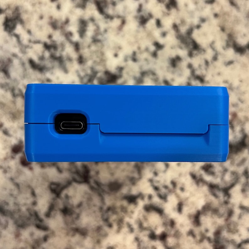 Op de afbeelding: Een blauw rechthoekig apparaat met een zwarte USB-C-poort aan de zijkant.