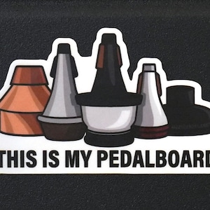 May include: A white sticker with a black outline featuring a row of five different colored musical instrument mouthpieces. The text "THIS IS MY PEDALBOARD" is printed below the mouthpieces.
