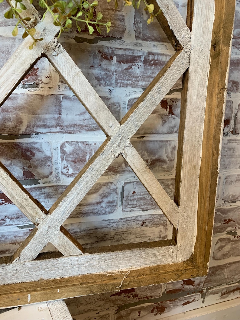 Puede incluir: Un elemento decorativo de pared de madera r&uacute;stica con un dise&ntilde;o de celos&iacute;a de diamantes. El marco es de madera natural con un acabado blanco envejecido. El fondo es una pared de ladrillo con pintura roja y blanca.