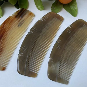 May include: Three handcrafted combs made from natural horn. The combs have a curved shape with fine teeth and decorative carved details. The colors range from light tan to dark brown. These combs are a unique hair care accessory.