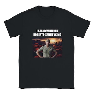 May include: Black t-shirt with the text "I STAND WITH BEN ROBERTS-SMITH VC MG" in white. The shirt features an image of a man in a military uniform standing in front of a sunset and a field of crosses.