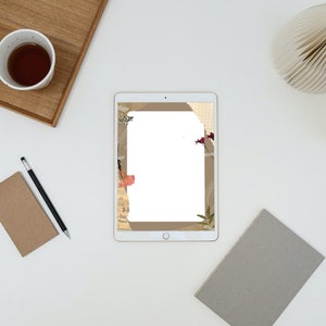 May include: A flat lay featuring a white tablet with a decorative border, a cup of tea, a notebook, a pencil, and a decorative paper fan. The items are arranged on a white surface, creating a minimalist aesthetic.