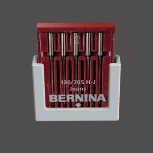 May include: A white plastic holder with a red plastic case of 10 sewing machine needles. The case has the text "130/705 H-J Jeans BERNINA" printed on it.