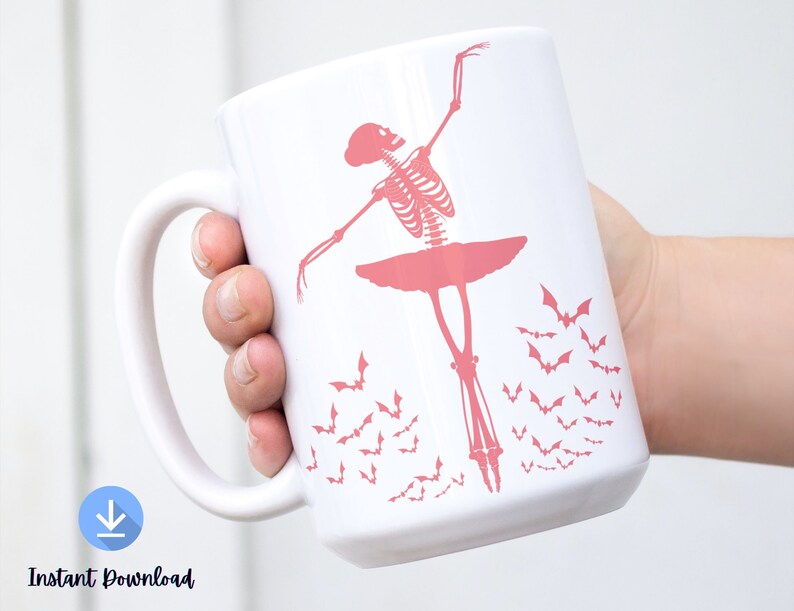 May include: White ceramic mug featuring a pink skeleton ballerina in a tutu, with bats flying around. The mug is held by a hand. The words "Instant Download" are at the bottom of the mug.
