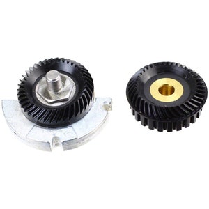 May include: Two black gear sets for a sewing machine. One gear has a silver base and a threaded screw in the center. The other gear has a brass center.