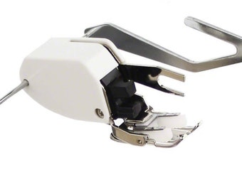 May include: A white and silver sewing machine foot with a black plastic piece. The foot is designed for rolled hems.
