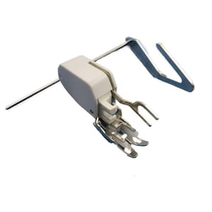 May include: A white plastic sewing machine foot with a metal attachment. The foot has a small lever on the side and a metal needle guide.