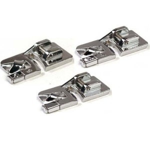 May include: Three silver sewing machine presser feet with a metal screw on each foot.