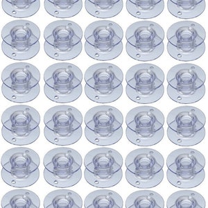 May include: A set of 36 clear plastic bobbins for sewing machines. The bobbins are stacked in rows of six.