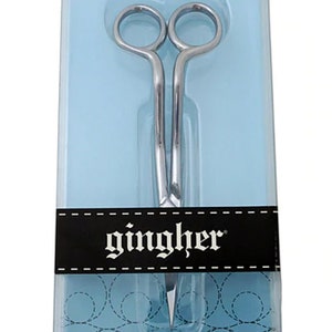 May include: A 6-inch pair of double-curved embroidery scissors in a clear plastic package with a black background. The scissors are silver and have the word "gingher" printed on the black background.