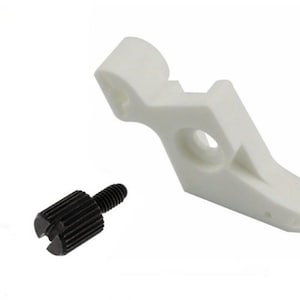 May include: A white plastic sewing machine foot with a black screw. The foot has a curved shape and a small hole in the center.