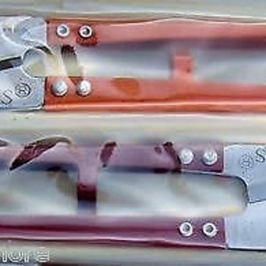 May include: Two pairs of small, red handled scissors with silver blades. The top pair has the text "MGS" on the blade. The bottom pair has the text "S.O.F.Z" on the blade.