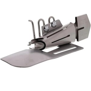 May include: A silver sewing machine foot for creating rolled hems. The foot has a guide to help create even folds and a plate to hold the fabric in place.