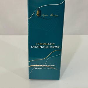 Puede incluir: Una caja turquesa de Aqua Marina Lymphatic Drainage Drop, un suplemento dietético. La caja presenta detalles dorados y el texto "HERBALS 1 fl oz (30 ml)". El producto está diseñado para apoyar la salud linfática.
