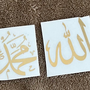 May include: Two white stickers with gold Arabic calligraphy. The first sticker says "Muhammad" and the second sticker says "Allah".